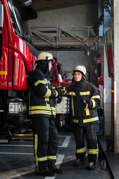 Male and female firefighters working together in suits and helmets