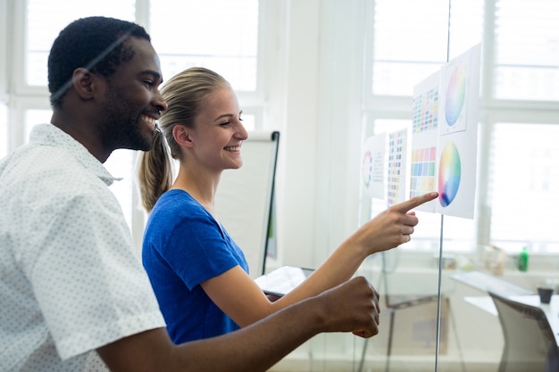 Free photo male and female graphic designers interacting over color chart