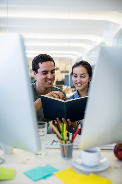 Free photo male and female graphic designers interacting over a diary