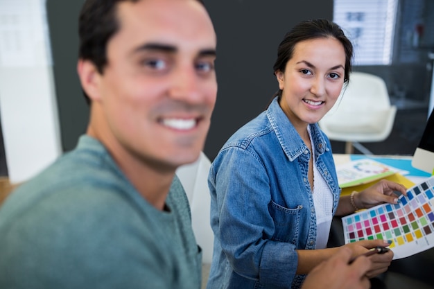 Male and female graphic designers smiling in office