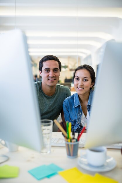 Male and female graphic designers smiling in office