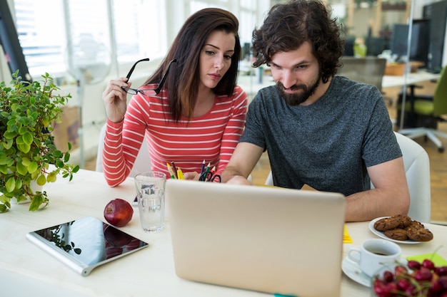 Male and female graphic designers using laptop