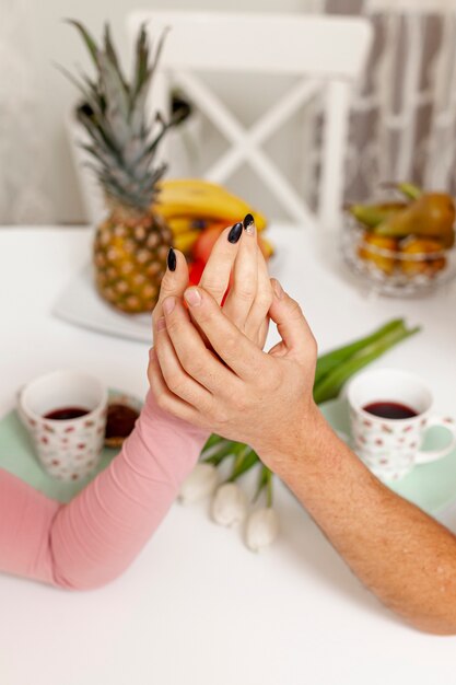 Male and female hands holding on table