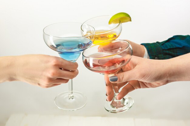 Male and female hands with exotic cocktails