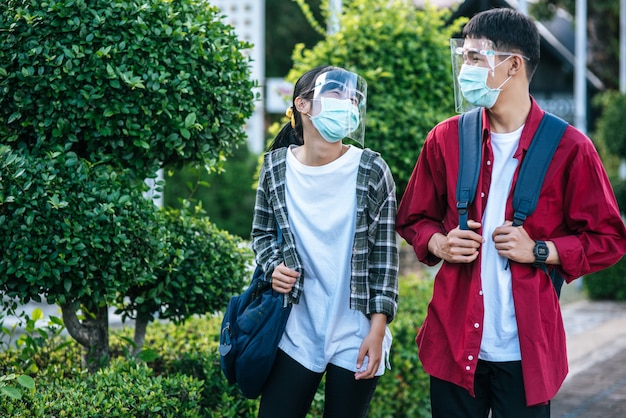 男性と女性の学生は顔寒さとマスクを着用します。