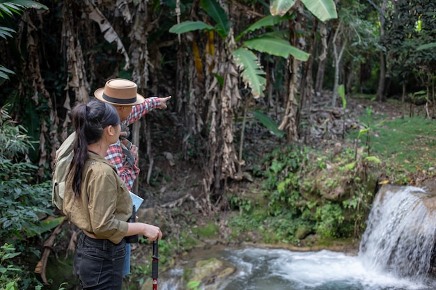 Free photo male and female tourists are enjoying the forest.