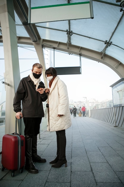 Туристы мужского и женского пола проверяют свой смартфон на улице