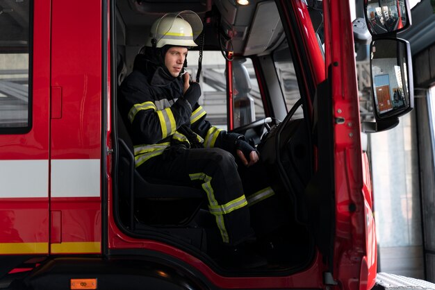 Male firefighter at station equipped with suit and safety helmet