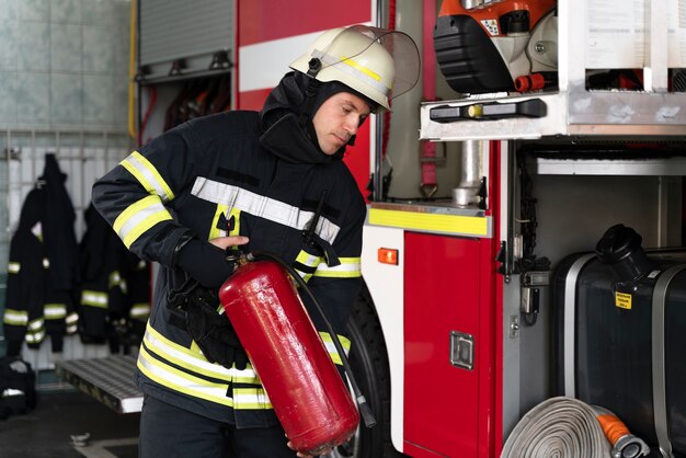 Male firefighter at station equipped with suit and safety helmet