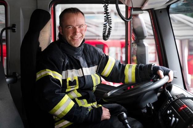 Male firefighter at the station inside fire truck