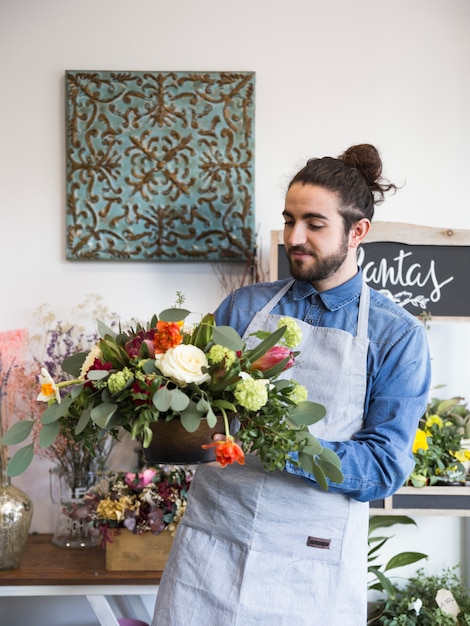 A male florist looking at flower decoration in his shop