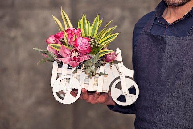 Male Florist promoting a car shaped mixed flower basket. 
