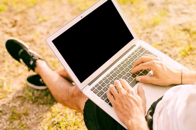 Male freelancer using laptop while working outside