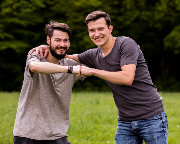 Male friends embracing in park