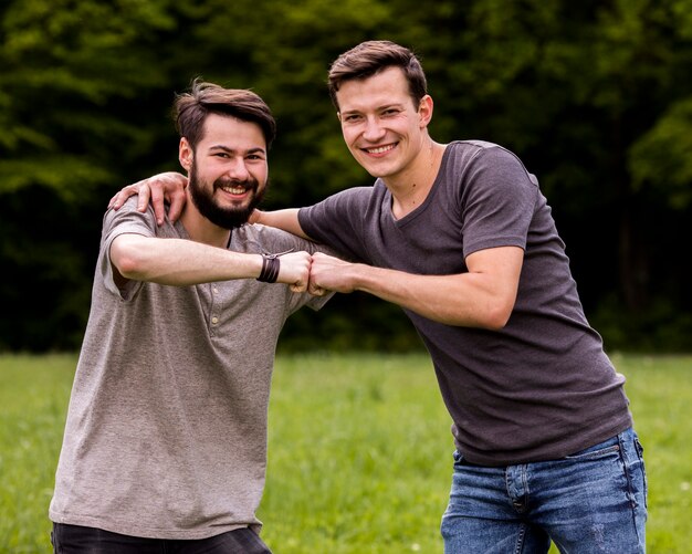 Male friends embracing in park