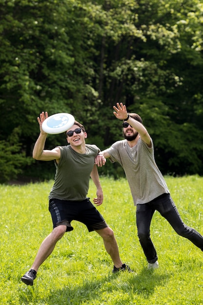 Male friends enjoying frisbee game in park