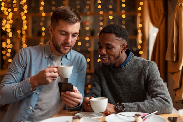 Free photo male friends looking at phone