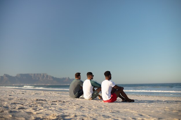 Male friends relaxing together on the beach
