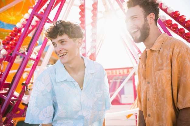 Free photo male friends in sunlight at funfair