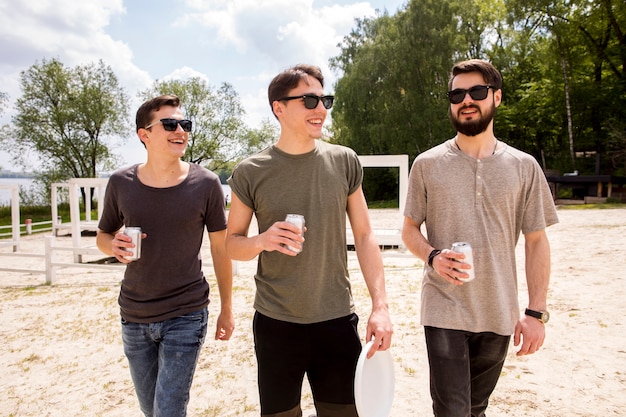 Male friends walking with beer