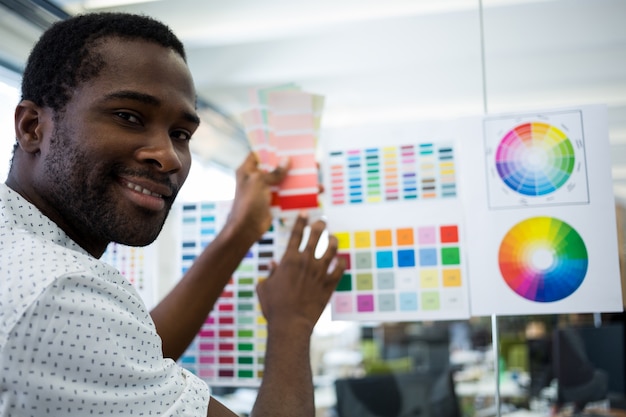 Male graphic designer holding color swatch