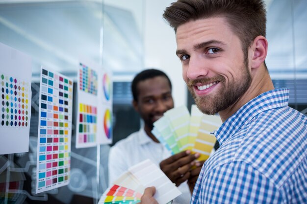 Male graphic designer holding color swatch