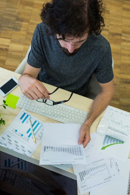 Male graphic designer looking at graph document