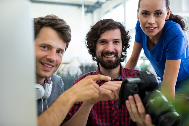 Male graphic designers showing pictures to his coworkers on camera