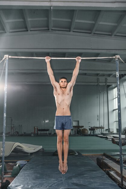 Male gymnast performing handstand on parallel bars