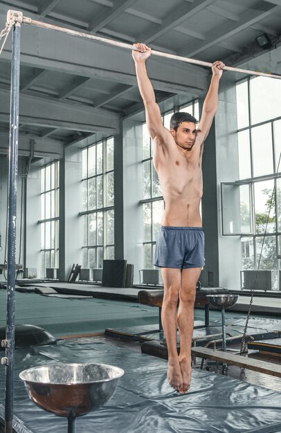 Male gymnast performing handstand on parallel bars