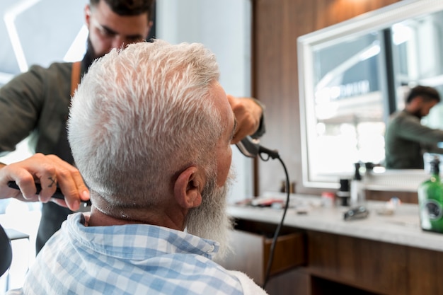 無料写真 シニアクライアントの男性美容師トリミング髪