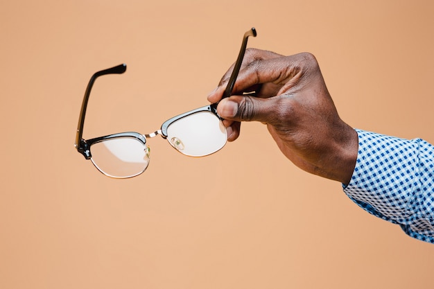 Male hand holding glasses, isolated