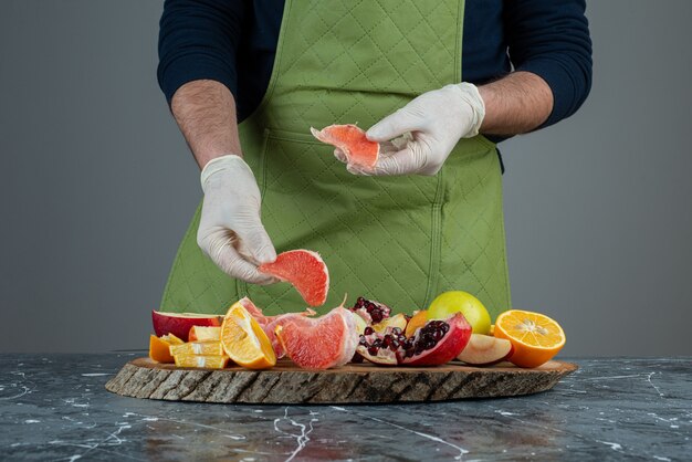 大理石のテーブルにジューシーなグレープフルーツを持っている男性の手。
