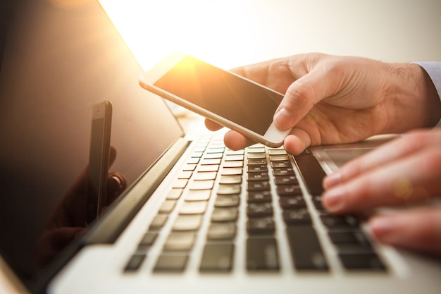 Mano maschile in possesso di un telefono