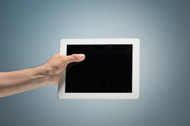 Male hand holding a tablet