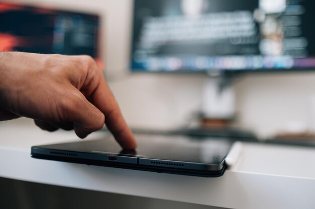 Male Hand Using His Finger Id On A Tablet At Home Or A Public Place To Make An Online Purchase