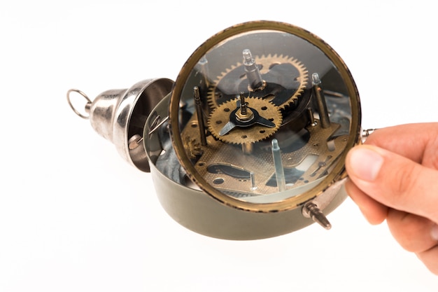 Male hand with magnifier and clockwork