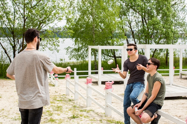 Male handing beer to friends