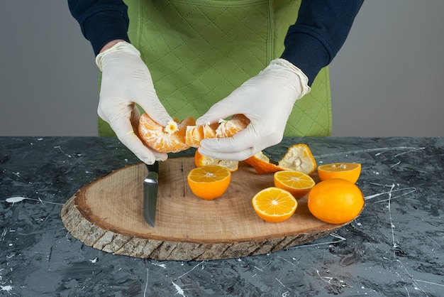 Free photo male hands holding juicy tangerine on marble table.