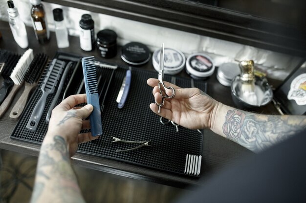 理髪店でひげを切るための男性の手と道具。理髪店のヴィンテージツール。