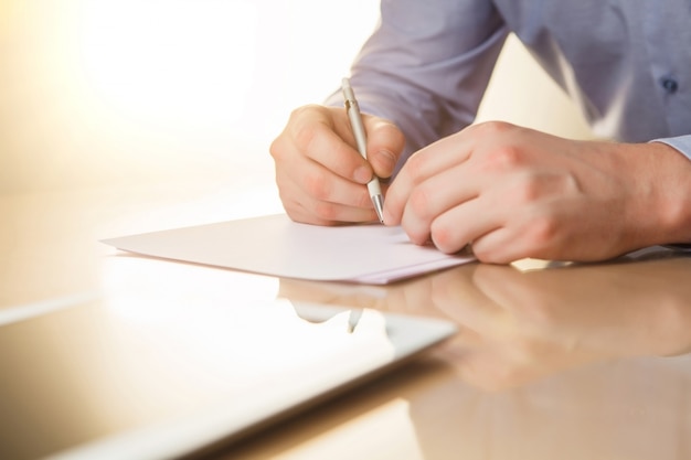 The male hands with a pen and the cup