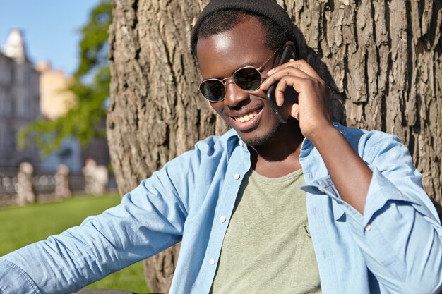 male having pleasant conversation with his girlfriend while sitting at green grass