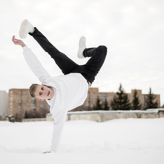 Free photo male hip hop artist dancing outside in the snow