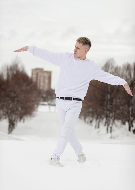 Male hip hop artist posing outside with snow