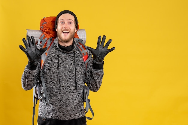 Free photo male hitchhiker with leather gloves and backpack raising hands