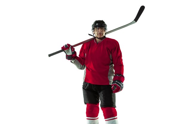 Male hockey player with the stick on ice court and white background.