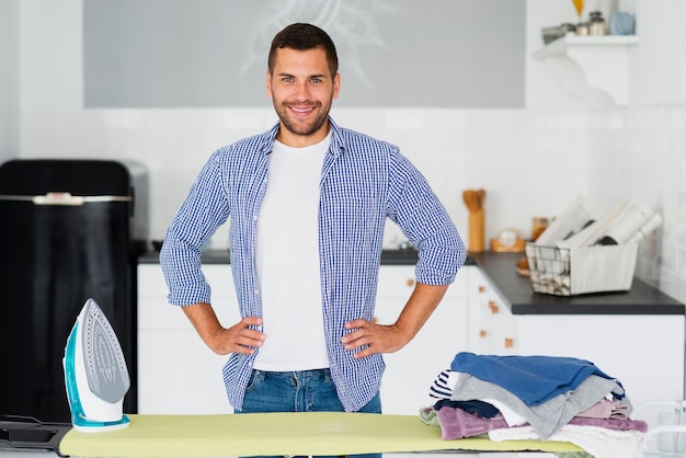 Foto gratuita maschio a casa preparando a stirare i vestiti