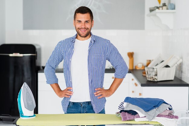 Male at home preparing to iron clothes