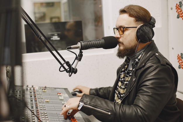 Free photo male host communicating on microphone. man in radio studio.