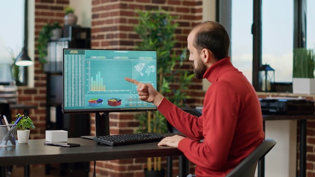 Male investor looking at stock trade sales on computer, using financial statistics to plan business investment for growth. Market analyst working with real time forex exchange graphs.